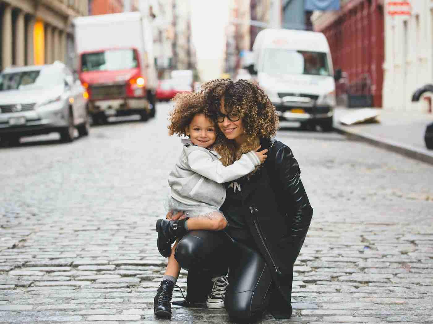 Woman hugging her daughter in the city