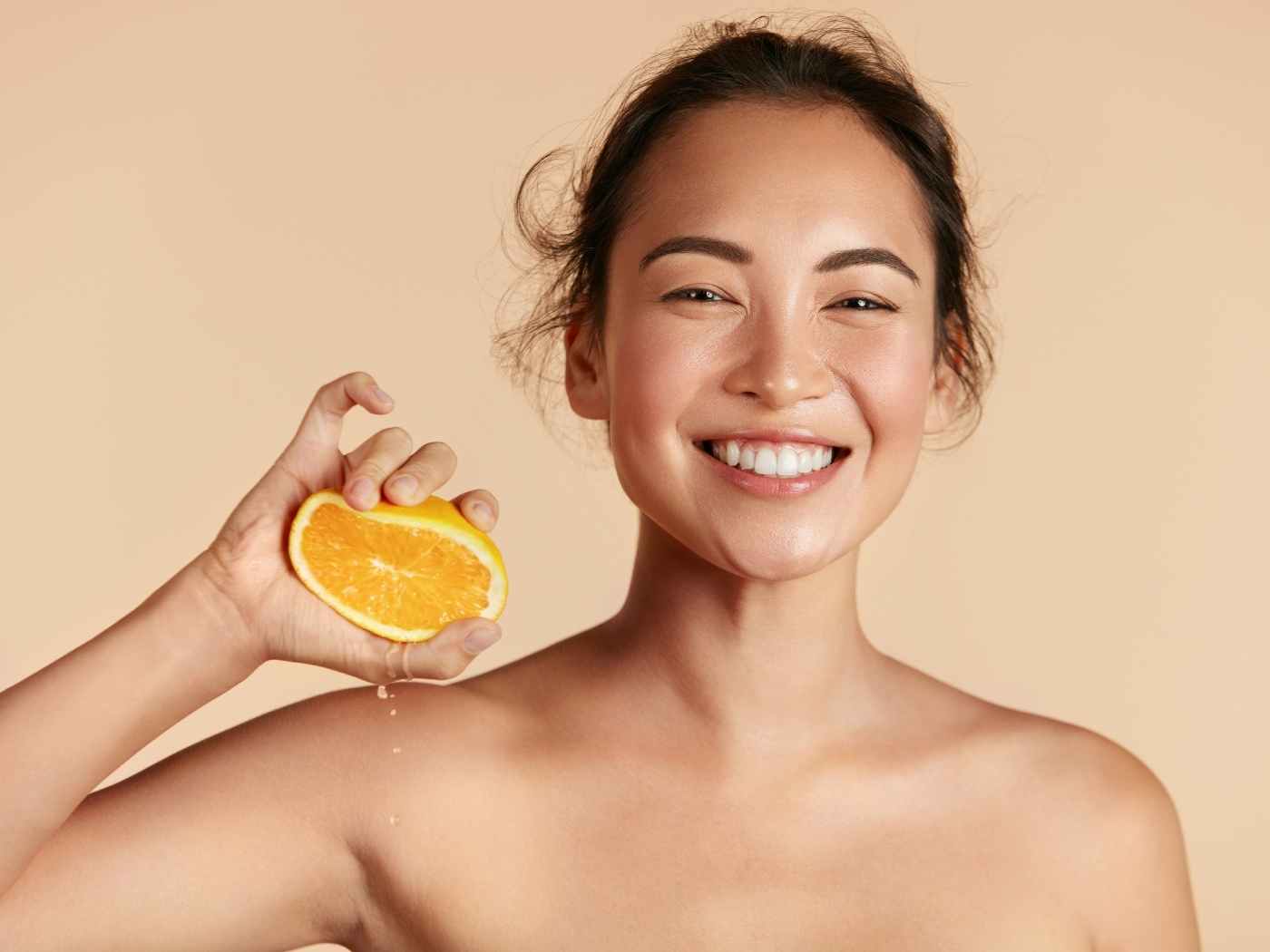 Woman Squeezing an Orange Smiling
